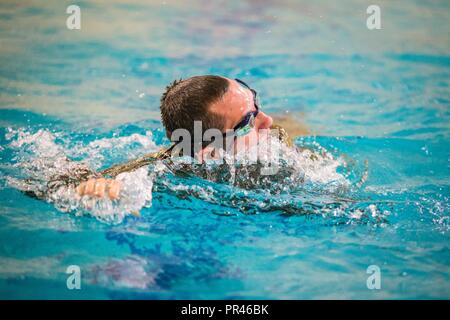 Us-Piloten und Soldaten aus verschiedenen Active Duty und National Guard Einheiten an einer 100-m-Schwimmen am Missouri Western State University, St. Joseph, Calif., Sept. 6, 2018. Der Service Mitglieder waren, für die die Bundeswehr Proficiency Badge, durch die 139 Airlift Wing, Missouri Air National Guard gehostet werden. Die Veranstaltung beinhaltet, Schwimmen, Sprints, Pull-up Running hängen, Pistole Treffsicherheit und ein Ruck März. Teilnimmt, kann in Bronze, Silber oder Gold Kategorien qualifizieren. Stockfoto