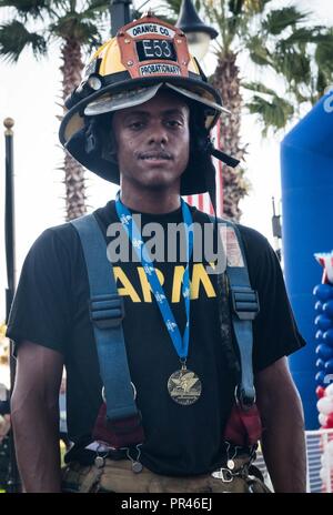 Eine Medaille kennzeichnet den erfolgreichen Abschluss der Orlando Tunnel zu Tower 5k Rennen hängt um den Hals der US-Armee SPC. Andy Meyreles (rechts), Munition und Accounting Specialist, Mission Support Element, 143 d Sustainment Command (auslandseinsätze). Meyreles, der auch als Feuerwehrmann und Rettungssanitäter für die Orange County Feuerwehr dient, und mehr als 50 Kameraden aus dem 143d ESC versammelt im Cranes Roost Park in Altamonte Springs, Fla., Sept. 8, 2018, die in diesem jährlichen Ereignis, die Kapital und das Bewusstsein für die Hunderte von ersten teilnehmen zu r Stockfoto