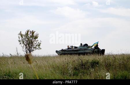 Die nationalflagge Wellen aus einem ukrainischen militärisches Fahrzeug in Ruhe bei einem Konzept operativer Fähigkeiten Bewertung des internationalen Friedens und der Sicherheit in Yavoriv, Ukraine, Sept. 11, 2018. Die Bewertung wurde von einem multinationalen OCC Bewertung Team während der schnellen Trident Übung der Ukraine die militärische Interoperabilität Kapazität zu bewerten. Stockfoto