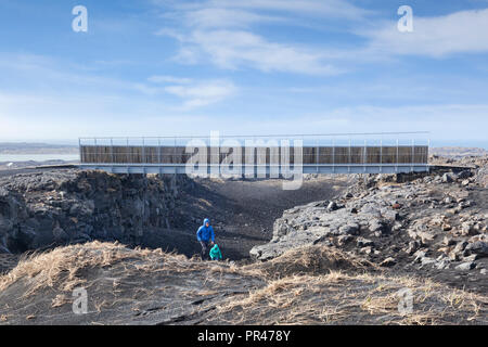 18. April 2018: Sandvik, Island - ein Paar aus der Schlucht auf die symbolische Brücke zwischen den Kontinenten in die Reykjanes Halbinsel, Island, Cros Stockfoto