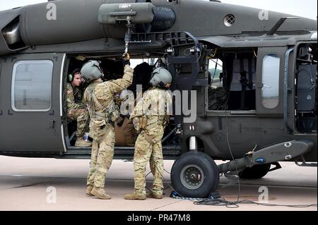 Sgt. Kelby Shifflett, Mitte, und Sgt. Anthony McCall, rechts, UH-60 Blackhawk Mannschaft Leiter, Charlie Company, 1-169 Allgemeine Unterstützung Aviation Battalion, Oklahoma Army National Guard, Verhalten vor der externen rescue Hoist vor Verlassen, um Hilfsmaßnahmen für Hurrikan Florence Sept. 13 zugewiesen sind, unterstützen. Sieben Soldaten aus der Luftfahrt im Hubschrauber Suche ausgebildet und Rettungsmaßnahmen schnell Wasser Verhalten rettet mit dynamischen und statischen Hebezeuge gestrandeten Bürger zu retten nach dem Hurrikan wieder abfließt. Stockfoto