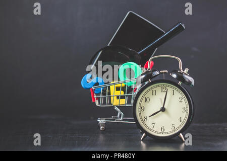 SEO Suchmaschinen Optimierung Konzept farbigen Buchstaben von SEO mit Uhr, Lupe, Smartphone, Zahnräder in einem Korb auf einem schwarzen Hintergrund Copysp Stockfoto