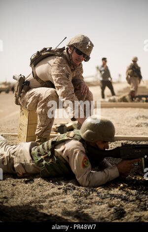 Ein Berater des US Marine Corps zugewiesene Aufgabe Force-Southwest Trainer ein Soldat mit der afghanischen nationalen Armee während eines M240B Maschinengewehr Sortiment am Lager Shorabak, in der Provinz Helmand, Afghanistan, Sept. 5, 2018. Der Bereich erlaubt Soldaten ihre tödliche und präzise Maschine Gewehr abfeuern Fähigkeiten zu verbessern und sie in die Erhaltung und den Ausbau der Sicherheitsgurt in der Provinz Helmand und sichere Wahlen zu erleichtern diese Oktober unterstützen. Stockfoto