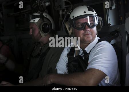 Mike Geld, ein Assistant Athletic Director an der Clemson Universität, beobachtet die Szenerie als MV-22 Flug dauert am Wilson Air Center beim Marine Corps' Marine Woche in Charlotte, North Carolina, Sept. 5, 2018. Charlotte ist die größte Stadt im Südosten und wächst. Durch die Partnerschaft mit Charlotte basierende regionale Organisationen und sich während der Veranstaltungen wie die Marine, Marine Corps Recruiting Befehl lokale Publikum sorgt für Ihre Botschaft der aspirational Dienst an der Nation alle Ecken des Landes erreicht. Stockfoto