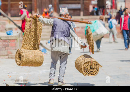 Kathmandu, Nepal - Sep 24,2018: Nepalesische Straßenhändler zu Fuß auf der Straße Kunsthandwerk aus Stroh in Kathmandu zu verkaufen Stockfoto