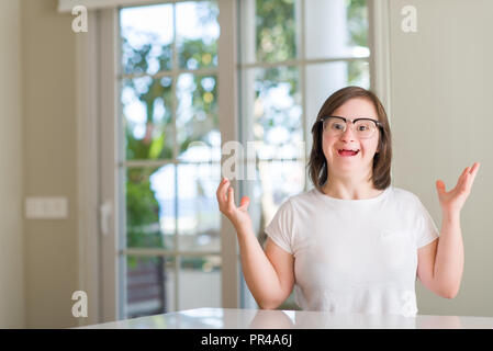 Down Syndrom Frau zu Hause sehr glücklich und aufgeregt, Sieger Ausdruck feiern Sieg schreien mit einem großen Lächeln und erhobenen Händen Stockfoto