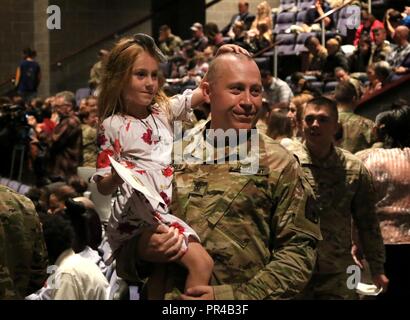 1. Sgt. Jason Barclay des 28 Military Police Company, 165 Military Police Battalion, 55th Manöver Verbesserung Brigade, 28 Infanterie Division, Pennsylvania Army National Guard, trägt seine Tochter Arianna während der abschiedszeremonie der Einheit Sept. 9 in Richland High School, Johnstown, Pa. Stockfoto