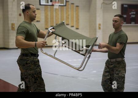 Us Marine Corps Sgt. Calvin Monteiro, Links, Munition, Techniker, und Lance Cpl. Jakob Tittle, administrative Spezialist, Sitz und Unterstützung Bataillon, Marine Corps Installationen Ost, Marine Corps Base Camp Lejeune, bis ein Babybett an der Wallace Creek Fitness Center im MCB Camp Lejeune, N.C., Sept. 11, 2018. Auf Basis Unterstände für alle autorisierten Personal bei der tropische Wirbelsturm Zustand I festgelegt ist. Camp Lejeune wird drei Hütten auf der Basis einschließlich Wallace Creek Fitnesscenter, Brewster mittleren Schule und Tarawa Terrasse Volksschule öffnen. Stockfoto