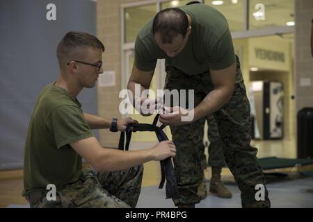 Us Marine Corps Pfc. William Dienno, Links, administrative Specialist und Sgt. Calvin Monteiro, rechts, Munition, Techniker, Sitz und Unterstützung Bataillon, Marine Corps Installationen Ost, Marine Corps Base Camp Lejeune, Binden ein Kinderbett an der Wallace Creek Fitness Center im MCB Camp Lejeune, N.C., Sept. 11, 2018. Auf Basis Unterstände für alle autorisierten Personal bei der tropische Wirbelsturm Zustand I festgelegt ist. Camp Lejeune wird drei Hütten auf der Basis einschließlich Wallace Creek Fitnesscenter, Brewster mittleren Schule und Tarawa Terrasse Volksschule öffnen. Stockfoto