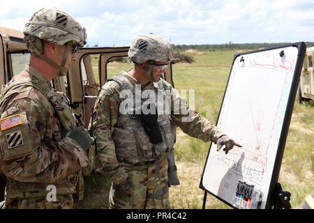 Kapitän Lorenz Hummel, Kommandeur der 24 Ordnance Loslösung, 87th Combat Sustainment Support Battalion, 3 Infanterie Division Sustainment Brigade, beschreibt Sektor seiner Loslösung von Feuer Karte zu oberst Jeffrey Britton, das 3. Inf. Div. Sust. Bde. Commander, während Base Defense live fire Übung des Bataillons, Sept. 7, Ft. Stewart, Ga. Die live fire Übung demonstriert die Fähigkeit des bataillons sich gegen einen feindlichen Angriff zu verteidigen. Stockfoto