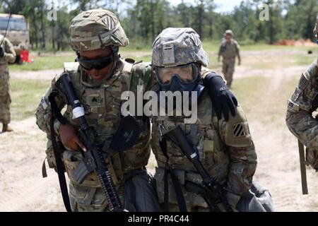 Pvt. Veronica Montes (rechts), eine Munition Spezialist, unterstützt Sgt. Keisha Henry (links), eine Munition Sergeant, sowohl mit den 24 Ordnance Loslösung, 87th Combat Sustainment Support Battalion, 3 Infanterie Division Sustainment Brigade, während Base Defense live fire Übung des Bataillons an Ft. Stewart, Ga., Sept. 7. Montes transportiert Henry, die simulierten Unfall, nachdem Sie ihren Puls und Anwendung eines Combat application Tourniquet zu Henry's Bein. Stockfoto