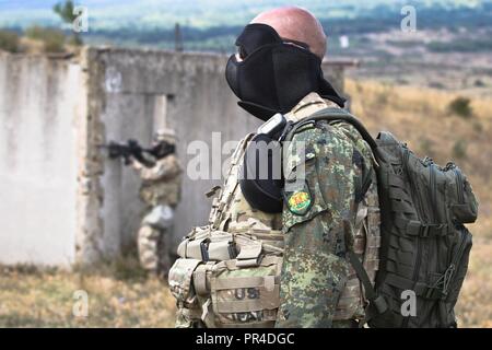 Die bulgarische Armee Kapitän Ferdinand Ferdinandov zu 61 mechanisierte Brigade zugeordnet, beobachtet der US-Army Soldaten aus Alpha Company, 2nd Battalion, 5th Cavalry Regiment, 1st Armored Brigade Combat Team, 1.Kavallerie Division, Durchführung oder militärische Operationen in urbanem Gelände Training, bestehend aus Kraft-auf-force Team Engagements mit M4-Karabiner und M249 leichte Maschinengewehre mit Simulation runden geladen, Novo Selo, Sept. 12, 2018. Diese Übung ist zur Unterstützung der Atlantischen lösen, ein bleibendes Training übung zwischen der NATO und der US-Streitkräfte. Stockfoto