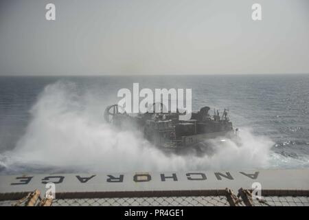 Golf von Aden (Sept. 10, 2018) Landing Craft, Luftkissen 75, zum Angriff Handwerk Einheit 5 angeschlossen ist, beendet das gut Deck von San Antonio - Klasse amphibious Transport dock Schiff USS Anchorage LPD (23), während der Teilnahme an Theater amphibischen bekämpfen Probe (TACR) 18. Geführt von Naval Amphibious Force, Task Force 51/5 th Marine Expeditionary Brigade, TACR integriert die US Navy und Marine Corps Vermögenswerte zu üben und eine Reihe von kritischen bekämpfen - ähnliche Funktionen für US Central Command, sowohl über Wasser und an Land, Stabilität und Sicherheit in der Region zu fördern. 5. US-Flotte und Koalition Stockfoto