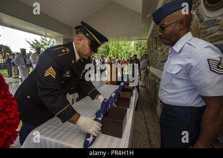 Us-Armee Sgt. Mike DeMayo, Links, eine Flagge vor eine Urne mit den cremains eines Veterans während der 30 New Jersey Mission der Ehre (NJMOH) Zeremonie an der Brigadier General William C. Doyle Veterans Memorial Friedhof im Norden Hannovers Township, N.J., Sept. 13, 2018. Die cremains von Lawrence H. Bischof, George Rat, Leo W. Feltman, Donald MacGuigan, Merritt T. Grün, Harold A. Naegely, Clyde E. Reeves, John T. Swanton, und Winfried J. Wiest, wurden während der Zeremonie geehrt. NJMOH's Mission ist es, zu identifizieren, Abrufen und intern die verbrannten Überreste der Veteranen im Neuen J vergessen Stockfoto