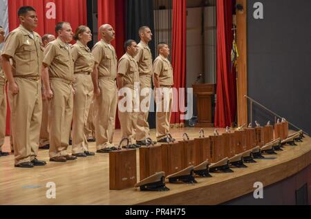 Flotte AKTIVITÄTEN Yokosuka, Japan (Sept. 14, 2018) Neu gefördert Chief Petty officers aus fünf Befehle über Flotte Aktivitäten Yokosuka warten ihre Anker während eines Chief Petty Officer pinning Zeremonie an der Flotte Theater zu erhalten. 14 Seeleute wurden zum Chef während der Veranstaltung erweitert. Stockfoto