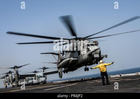 Golf von Aden (Sept. 10, 2018) Ein CH-53E Super Stallion Hubschrauber, die an der "Elche" der Marine Medium Tiltrotor Squadron (VMM) 166 (Lauf), startet von der Flight Deck von Wasp-Klasse amphibisches Schiff USS Essex (LL 2) während der Teilnahme an Theater amphibischen Kampagne Probe (TACR) 18. Geführt von Naval Amphibious Force, Task Force 51/5 th Marine Expeditionary Brigade, TACR integriert die US Navy und Marine Corps Vermögenswerte zu üben und eine Reihe von kritischen bekämpfen - ähnliche Funktionen für US Central Command, sowohl über Wasser und an Land, Stabilität und Sicherheit zu fördern Proben Stockfoto