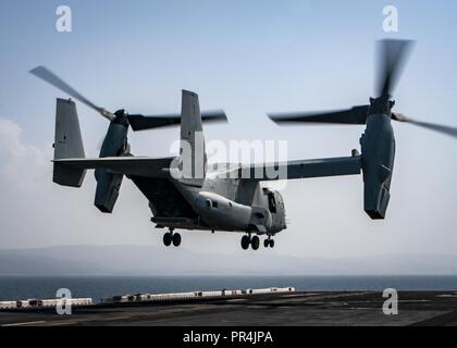 Golf von Aden (Sept. 10, 2018) Eine MV-22 Osprey tiltrotor Aircraft, die an der "Elche" der Marine Medium Tiltrotor Squadron (VMM) 166 (Lauf), startet von der Flight Deck von Wasp-Klasse amphibisches Schiff USS Essex (LL 2) während der Teilnahme an Theater amphibischen Kampagne Probe (TACR) 18. Geführt von Naval Amphibious Force, Task Force 51/5 th Marine Expeditionary Brigade, TACR integriert die US Navy und Marine Corps Vermögenswerte zu üben und eine Reihe von kritischen bekämpfen - ähnliche Funktionen für US Central Command, sowohl über Wasser und an Land, Stabilität und Sicherheit zu fördern Proben Stockfoto