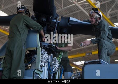 Us Marine Corps Sgt. Jose Espitia, Sicherheiten verpflichtet, Qualitätssicherung, Lance Cpl. Victor Starke, Lance Cpl. Mathew Nelson, UH-1Y crew Chiefs, Marine Light Attack Helicopter Squadron 775, 4 Marine Flugzeugflügel, arbeiten zusammen, um eine Taumelscheibe auf einem Bell AH-1Z Viper Kampfhubschrauber des Marine Corps Air Station Camp Pendleton, Kalifornien, Sept. 14, 2018. Brandschutzinspektionen sollen alle 50 Stunden zu schützen die Bell AH-1Z Viper Angriffshubschrauber, und reparieren Sie sie. Stockfoto