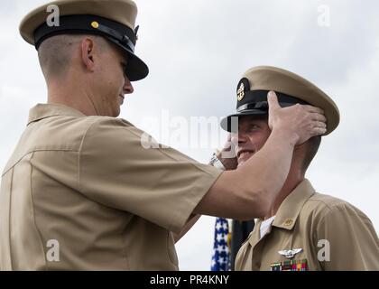 HARBOR, Washington (Sept. 14, 2018) - Chief Aviation strukturellen Mechaniker Kevin Leonard hat seine Deckung während der Naval Air Station Whidbey Island (NASWI) Chief Petty Officer (CPO) Pinning Zeremonie angezogen. Die Zeremonie markiert den ersten Iteration von Sailor360 und der Höhepunkt einer sechs-wöchigen intensiven Training Zyklus, der von fast zwei gebaut wurde und ein halb Jahrhunderten der Naval Erbe und 125 Jahre CPO Tradition. VP-46 hat vor Kurzem vom Rand der Pazifischen Übung zurückgegeben und ist derzeit in der NASWI stationiert. Die "Graue Ritter" sind in Vorbereitung für eine bevorstehende Bereitstellung und ihre endgültige de Stockfoto