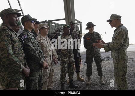 U.S. Navy Bootsmann 1. Klasse Antonio Caia mit Küsten Riverine Squadron (CRS) 8, Schriftsatz ausländischen Verbindungsbeamten in Combined Joint Task Force-Horn Afrika auf Lager Lemonnier, Dschibuti, Sept. 14, 2018 zugeordnet. Caia sprach über die Art der Patrouillenboote, CRS8 verwendet, und gab ihnen einen Rundgang durch das Schiff. Stockfoto