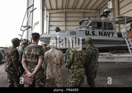 U.S. Navy Bootsmann 1. Klasse Antonio Caia mit Küsten Riverine Squadron (CRS) 8, Schriftsatz ausländischen Verbindungsbeamten in Combined Joint Task Force-Horn Afrika auf Lager Lemonnier, Dschibuti, Sept. 14, 2018 zugeordnet. Caia sprach über die Art der Patrouillenboote, CRS8 verwendet, und gab ihnen einen Rundgang durch das Schiff. Stockfoto