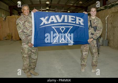 Us-Armee Generalleutnant Michael X. Garrett, US-Army Central Commander, hält einen der Xavier Universität Flagge mit US Army 1st Lieutenant Jane Fox, Terrorismusbekämpfung auszubilden und auszurüsten Fund Officer Leiter, im Al Asad Air Base, Irak, 14. September 2018. Generalleutnant Garrett und 1 Lt Fuchs sind beide Alumni der Xavier Universität. Stockfoto