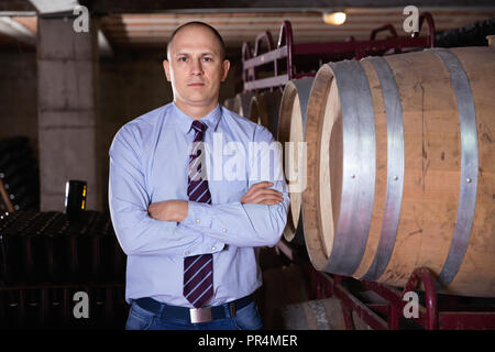 Sicher froh, heiter positive erfolgreiche Mann Winzer im eigenen Weingut vault Posing Stockfoto