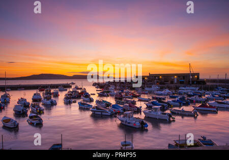 Lyme Regis, Dorset, Großbritannien. 29. September 2018. UK Wetter: der Himmel über dem Cobb Hafen glühen mit leuchtenden Farben zu Beginn eines sonnigen Tages in Lyme Regis. Credit: Celia McMahon/Alamy leben Nachrichten Stockfoto