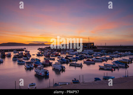 Lyme Regis, Dorset, Großbritannien. 29. September 2018. UK Wetter: der Himmel über dem Cobb Hafen glühen mit leuchtenden Farben zu Beginn eines sonnigen Tages in Lyme Regis. Credit: Celia McMahon/Alamy leben Nachrichten Stockfoto