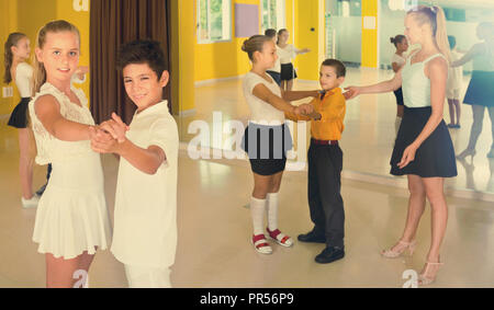 Gruppe von fleißigen freundlich lächelnden positive Kinder Tango tanzen im Tanzstudio Stockfoto