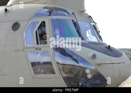 Ein U.S. Army CH-47 Chinook Helicopter Pilot die 12 Combat Aviation Brigade zugeordnet wartet für Soldaten an Bord während Sabre Junction 2018 an der 7th Army Training Befehl Grafenwöhr Training Area, Germany, Sept. 11, 2018. Übung Sabre Kreuzung 18 ist eine US-Army Europe - Geleitete Übung konzipiert, der die Bereitschaft der 173Rd Airborne Brigade der US-Armee unified Land arbeiten in einer gemeinsamen auszuführen, zu bewerten, kombinierte Umwelt und Interoperabilität mit teilnehmenden Verbündete und Partner Nationen zu fördern. Stockfoto