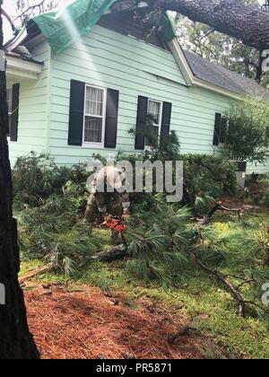 Us Border Patrol Suche Trauma und Rettung (BORSTAR) Teammitglieder einen umgestürzten Baum vom Dach eines Hauses in der Nähe von Wilmington, North Carolina entfernen, nach dem Hurrikan Florenz. CBP Stockfoto