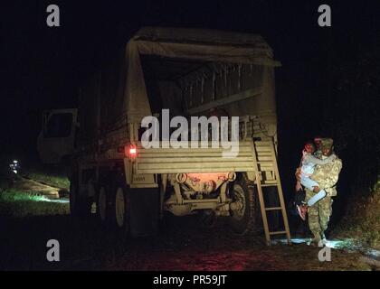 Südcarolina Army National Guard Soldaten mit der 1053Rd Transport Unternehmen eine Familie, die sich in Ihrem Fahrzeug während der frühen Morgenstunden als Folge des Hochwassers auf der Fahrbahn in Hamer, South Carolina, Sept. 18, 2018 gefangen war. Rund 3.090 Soldaten und Piloten werden mobilisiert zu reagieren und in der Wiederaufnahme Bemühungen in den Gemeinden als Tropischer Sturm Florenz Überschwemmungen und Schäden an den Mitgliedstaat verursacht hat. Stockfoto