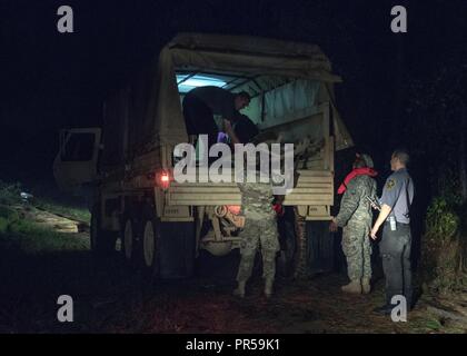 Südcarolina Army National Guard Soldaten mit der 1053Rd Transport Unternehmen eine Familie, die sich in Ihrem Fahrzeug während der frühen Morgenstunden als Folge des Hochwassers auf der Fahrbahn in Hamer, South Carolina, Sept. 18, 2018 gefangen war. Rund 3.090 Soldaten und Piloten werden mobilisiert zu reagieren und in der Wiederaufnahme Bemühungen in den Gemeinden als Tropischer Sturm Florenz Überschwemmungen und Schäden an den Mitgliedstaat verursacht hat. Stockfoto