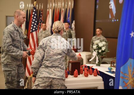 Maj. James Nelson, 30 Sicherheitskräfte Squadron Commander, und die Mitarbeiter der Sgt. Tiffany Kern, 30 Sicherheitskräfte Squadron Hundeführer, KONG Bälle auf der Kennel von militärischen Gebrauchshund Blecki während einer Trauerfeier Sept. 17, 2018, auf der Vandenberg Air Force Base, Calif. Kern wurde die MWD Blecki letzte Handler. Stockfoto