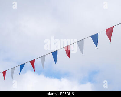 Rot, Weiß und Blau festliche bunting Fahnen gegen Himmel Hintergrund. Dreieck formen. Stockfoto