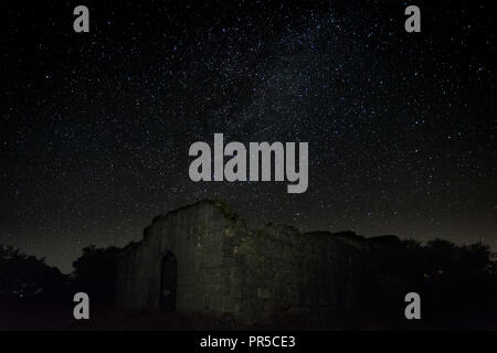 Nacht der Fotografie mit den Ruinen einer alten Einsiedelei in der Nähe von Guijo de Granadilla entfernt. Ermita de Hojaranzo. Extremadura, Spanien. Stockfoto