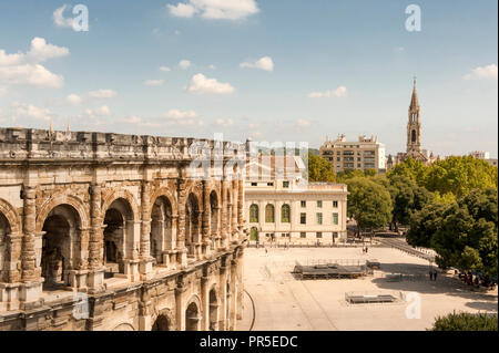 Das römische Erbe von Nîmes: Die'Arènes". Die Arena heute für Stierkämpfe und gallo-römische Spiele verwendet wird. Rechts: Église Kirche Sainte-Perpétue Stockfoto