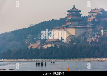 Menschen auf dem zugefrorenen See vor der Pagode der Sommerpalast von Peking, China Stockfoto