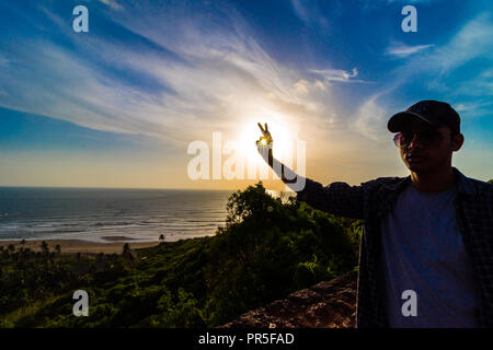 Vagator Beach - Sonnenuntergang Strahlen in den Rahmen um die Grüne natürliche Schönheit von Goa, Indien erfasst. Stockfoto