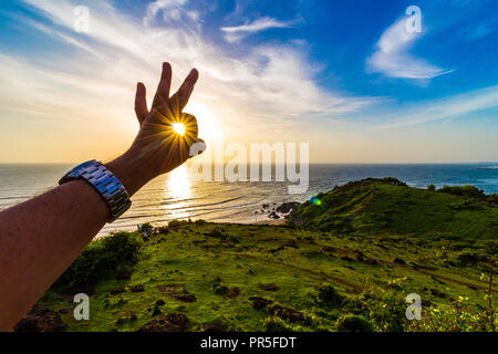 Vagator Beach - Sonnenuntergang Strahlen in den Rahmen um die Grüne natürliche Schönheit von Goa, Indien erfasst. Stockfoto