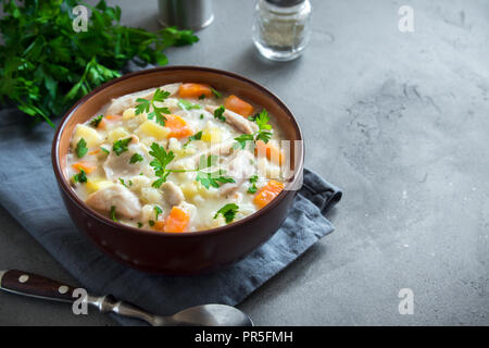 Huhn und wilder Reis Suppe. Hausgemachte frische cremige Suppe mit Hähnchen, Gemüse und Wildreis in weiße Schüssel. Stockfoto