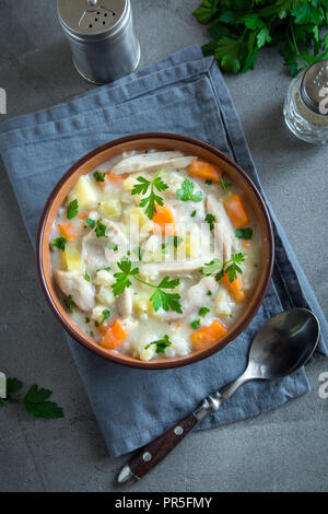 Huhn und wilder Reis Suppe. Hausgemachte frische cremige Suppe mit Hähnchen, Gemüse und Wildreis in weiße Schüssel, Ansicht von oben. Stockfoto