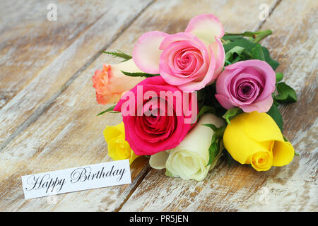 Happy Birthday Karte mit bunten Blumenstrauß aus Rosen auf rustikalem Holz Stockfoto