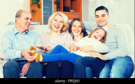 Lächelnd groß vereint Familienmitglieder zusammen im Wohnzimmer Stockfoto