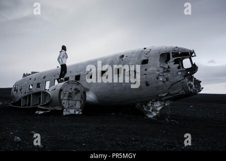 Solheimasandur Flugzeug Wrack Island mit Frau stehend auf Ebene Stockfoto