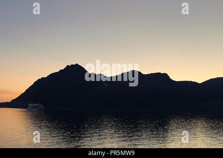 Das Kreuzfahrtschiff, Seabourn Ovation, Segel durch die Lauksundet, in der Nähe von Skjervøy, nördlich des Norwegischen Polarkreises bei Sonnenuntergang. Stockfoto