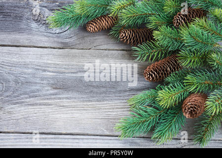 Weihnachten vintag Rahmen aus Tannenzapfen und Zweige auf dem Hintergrund der alten unlackierte Holz Fichte; mit copy-Raum Stockfoto