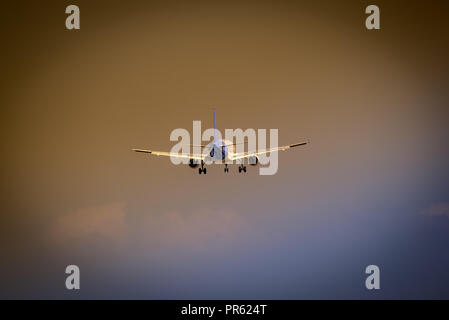 Grosses Flugzeug fliegen auf crazy dark sky mit land Gang nach unten Stockfoto