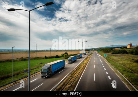 Wohnwagen oder Konvoi der blaue Lkw Lkw in Linie auf ein Land Autobahn Stockfoto